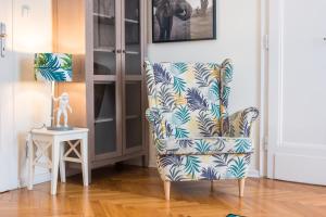 una silla azul y blanca en una habitación con mesa en Trip Apartments en Cracovia