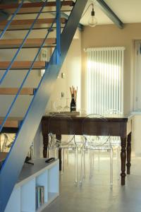 ein Esszimmer mit einem Tisch und Stühlen unter einer Treppe in der Unterkunft La Basiglia Apartment in Monforte dʼAlba