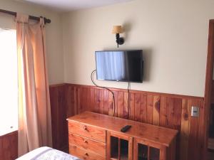 1 dormitorio con TV en la pared y vestidor en Departamento Pucon, en Pucón