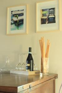 einen Tisch mit einer Flasche Wein und Gläsern in der Unterkunft La Basiglia Apartment in Monforte dʼAlba