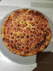 een pizza zittend op een bord op een tafel bij L'Escarbotine in Friville-Escarbotin