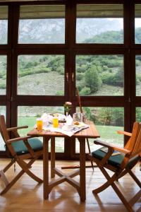 a table and chairs in a room with a large window at Parador de Fuente Dé in Fuente Dé