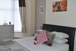 ein Schlafzimmer mit einem Bett mit Kissen darauf in der Unterkunft Adelaide Apartments in Blackpool