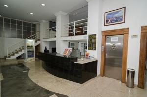 a lobby of a building with a ticket counter at Hotel Indaiá in Maringá