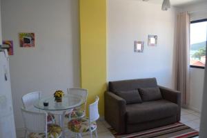 sala de estar con sofá, mesa y sillas en Residencial mar dos ingleses, en Florianópolis