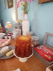 une table avec un gâteau sur une assiette et un vase dans l'établissement L'Escarbotine, à Friville-Escarbotin