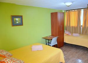 a room with two beds and a table with a desk at Hostal Terra 1 - ANDALUCÍA in Quito