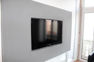 ein Flachbildfernseher an einer weißen Wand in der Unterkunft Atelier 3 - Boutique Rooms in Loulé