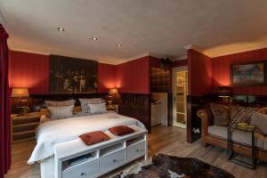 a bedroom with a large bed with red walls at Beck's Bed and Breakfast in Kaatsheuvel