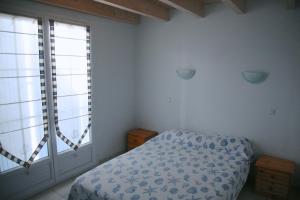 Grand-Village-PlageにあるHotel Residence Les Alizesのベッドルーム1室(ベッド1台、大きな窓2つ付)