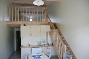 una cocina con una escalera que conduce a un loft en Hotel Residence Les Alizes en Grand-Village-Plage