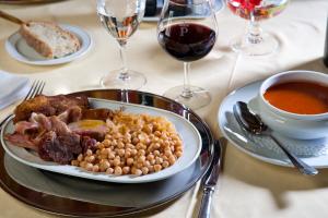 a plate of food with beans and meat and a glass of wine at Parador de Fuente Dé in Fuente Dé