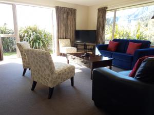 a living room with a couch and chairs and a table at Travels Rest in Franz Josef
