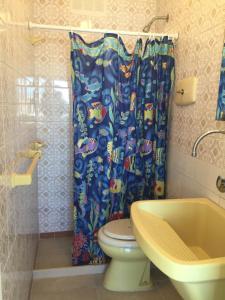 a bathroom with a toilet and a shower curtain at Edificio El Trébol in Punta del Este