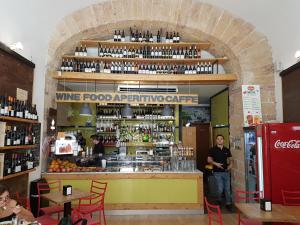 a man standing in front of a wine food restaurant at Maqueda Home in Palermo