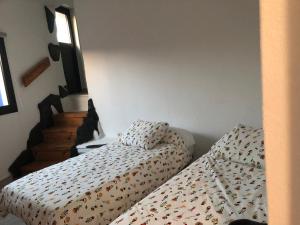 sypialnia z 2 łóżkami i klatką schodową w obiekcie Yasmina w mieście Lajares