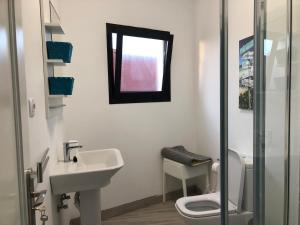 a bathroom with a sink and a toilet and a window at Yasmina in Lajares