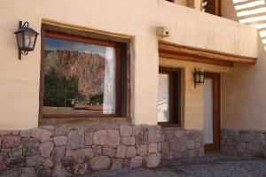 un edificio con ventana y pared de roca en Casa De Piedra en Purmamarca