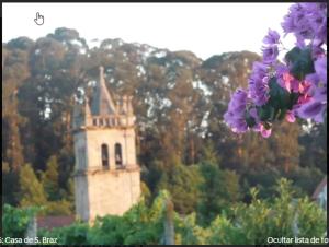 ein Gebäude im Hintergrund mit lila Blumen im Vordergrund in der Unterkunft São Braz Terrace in Landim