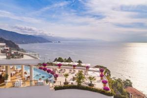 Grand Miramar All Luxury Suites & Residences في بويرتو فايارتا: اطلالة جوية على المحيط من المنتجع