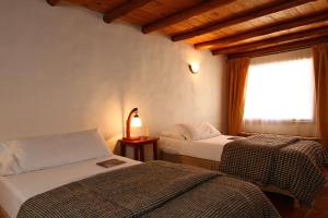 プルママルカにあるカサ デ ピエドラのベッド2台と窓が備わるホテルルームです。