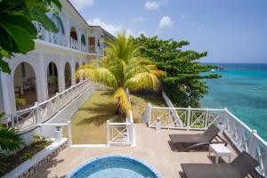 a beach with a balcony overlooking the ocean at Hibiscus Lodge Hotel in Ocho Rios