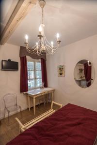 ラ・モッラにあるVilla Goccia di Vinoのベッドルーム1室(ベッド1台、テーブル、シャンデリア付)