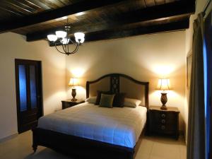 a bedroom with a bed with two night stands and two lamps at Hotel Boutique Rancho San Jorge in Bernal