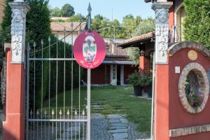 ein Tor mit einem Schild vor einem Haus in der Unterkunft Villa Goccia di Vino in La Morra