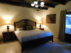 a bedroom with a bed with two lamps and a window at Hotel Boutique Rancho San Jorge in Bernal
