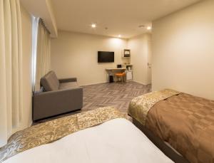 a hotel room with a bed and a chair and a desk at SARASA HOTEL Shin-Osaka in Osaka