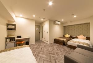 a hotel room with two beds and a desk at SARASA HOTEL Shin-Osaka in Osaka +29 photos