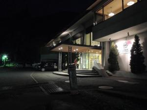 a woman standing outside of a building at night at Breezbay Lake Resort Kawaguchiko in Fujikawaguchiko