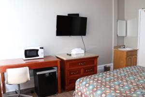 ein Hotelzimmer mit Bett und Schreibtisch mit Fernseher in der Unterkunft Europa Hotel in San Francisco