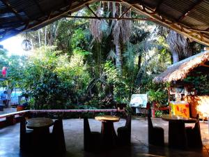 een groep banken en tafels in een tuin bij Villa Hermosa de Tambopata Casa Hospedaje & Hostel in Puerto Maldonado