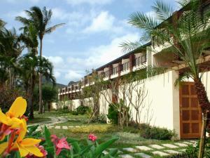 un complexe avec des palmiers et des fleurs devant lui dans l'établissement Caesar Park Hotel Kenting, à Kenting