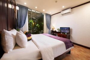 een slaapkamer met een groot bed en een televisie bij Impressive Boutique Hotel in Hanoi