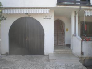 una entrada a un edificio con garaje negro en Apartments Lukacic, en Krk