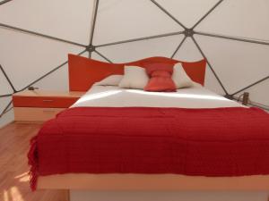 a bedroom with a large red bed with a frame at Punta de domos in Punta de Choros
