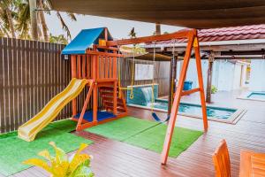 un parque infantil con tobogán y columpio en Ramada Suites by Wyndham Wailoaloa Beach Fiji, en Nadi