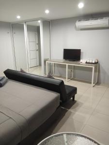 um quarto com uma cama e uma secretária com um computador em Asia's Beach Apartments em Sattahip