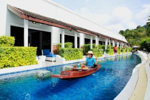 una chica en un barco en el agua en un resort en Access Resort & Villas - SHA Plus en Karon
