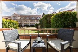 a patio with two chairs and a table with a bottle of wine at Mercure Canberra in Canberra