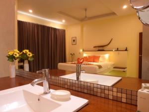 ein Bad mit einem Waschbecken und ein Bett in einem Zimmer in der Unterkunft Chuan Chom Villas in Lamai