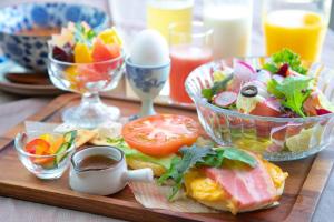 stół z tacą z jedzeniem, sałatką i jajkami w obiekcie Hotel Aile w mieście Beppu