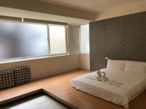 a bedroom with a bed and a large window at Happiness Dot in Tamsui