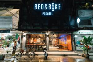 a store front with bikes parked outside at night at Bed & Bike Hostel in Chiang Rai