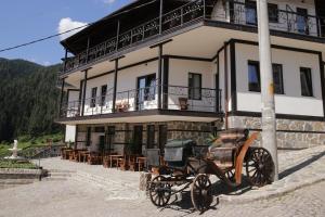 a horse drawn carriage parked in front of a building at Family hotel Valchanovata Kashta in Fotinovo
