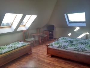 1 dormitorio con 2 camas, mesa y ventanas en Bakster en Władysławowo