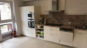 a kitchen with white cabinets and a counter top at Terra Rossa in Fiss